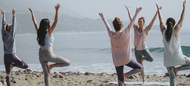 women doing yoga at the beach