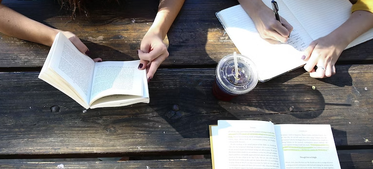 3 people reading outside