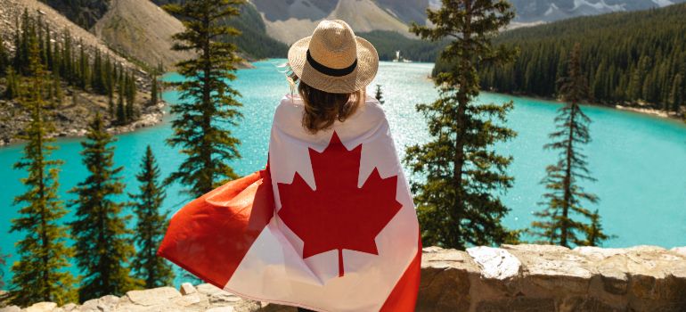 woman overlooking a lake draped in Canada's flag