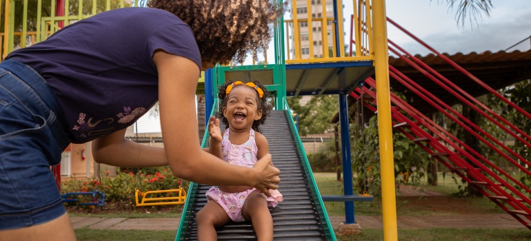 A child on a slide with her mother