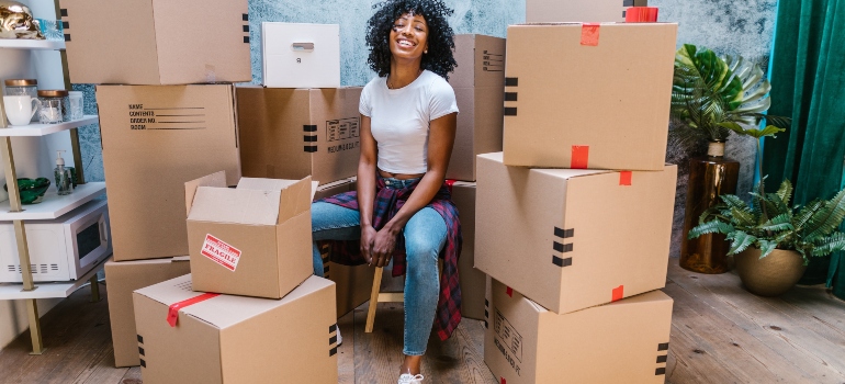 a woman sitting next to a pile of boxes