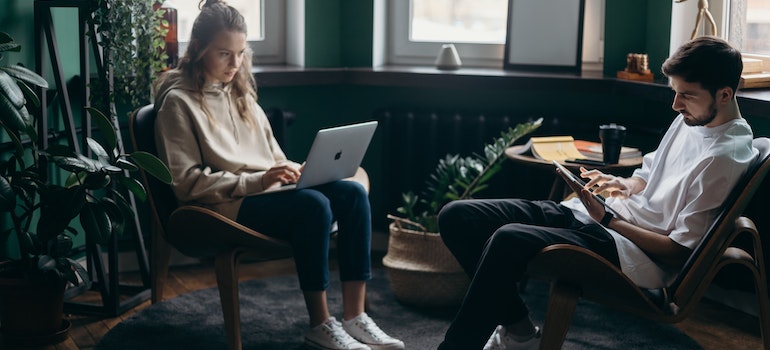 a man and a woman sitting and reading on a laptop about moving from East York to Thornhill