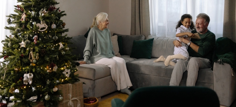 Two seniors and their grandchild sitting on the sofa
