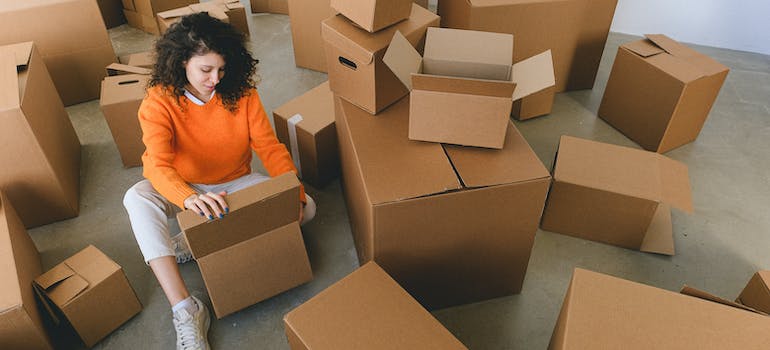 A person surrounded by boxes to be used to clear storage space