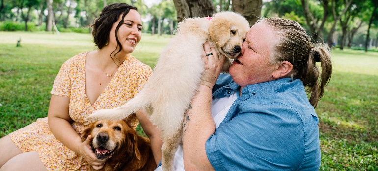 two women playing with dogs in one of the pet-friendly neighborhoods in GTA