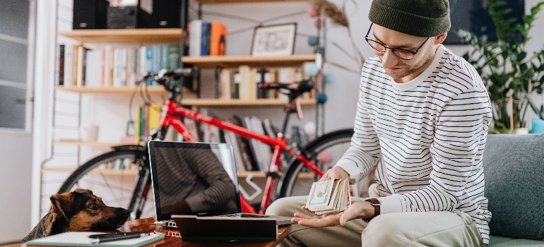 a person counting money after reading about financial tips for moving to the US from Canada