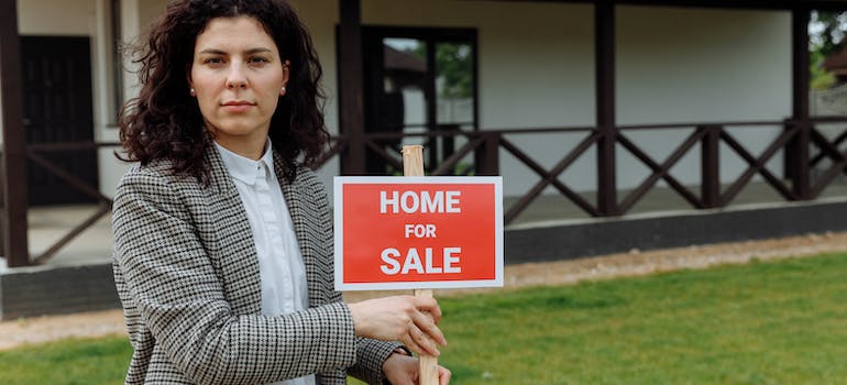 a real estate agent showing house for sale sign