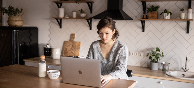 Woman reading about what to expect and what to avoid when movers pack for you on her laptop