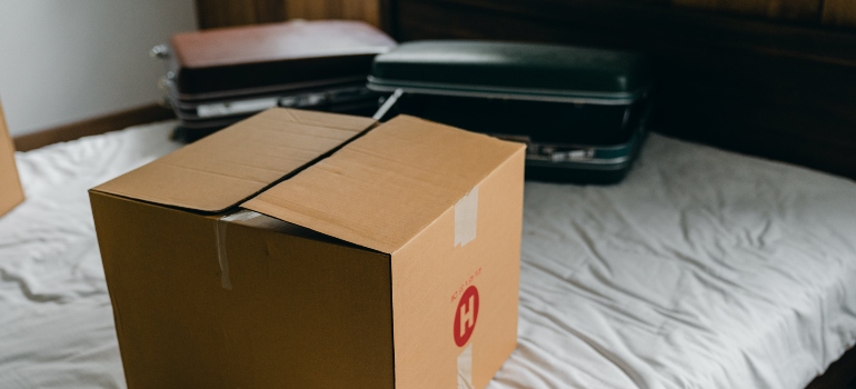 A box and two suitcases on a mattress