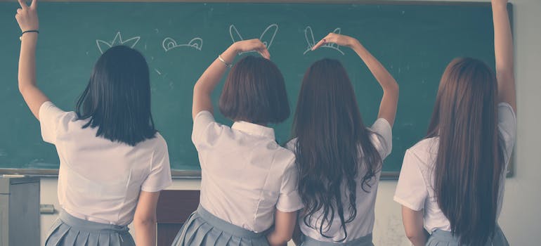 four girls in the school sitting on the table