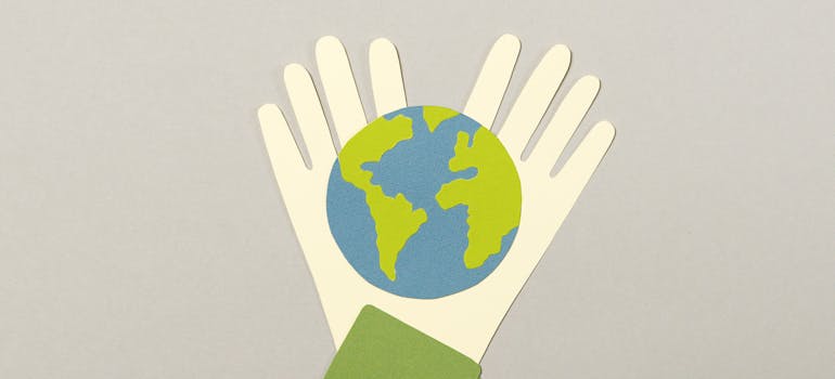 a photo of two paper hands holding the Earth.