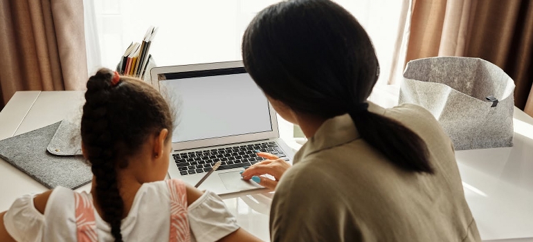 A mother is helping her daughter with homework.