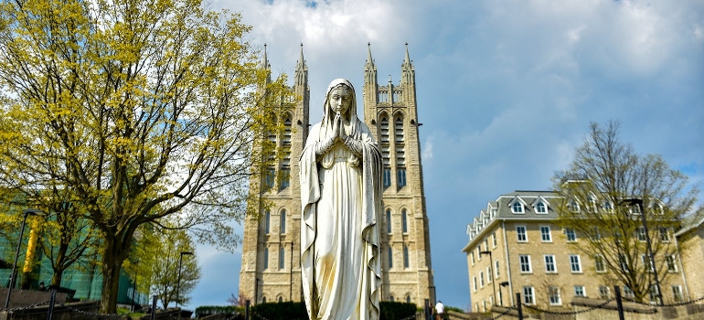 A Virgin Mary statue and church behind in Guelph which is one of best places to retire in Canada.