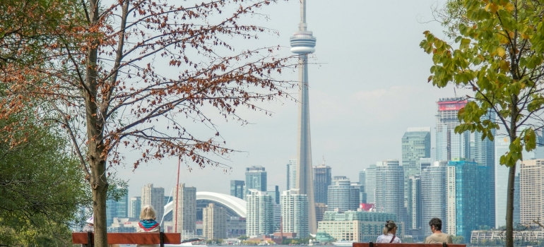 People are sitting on benches in Toronto park.