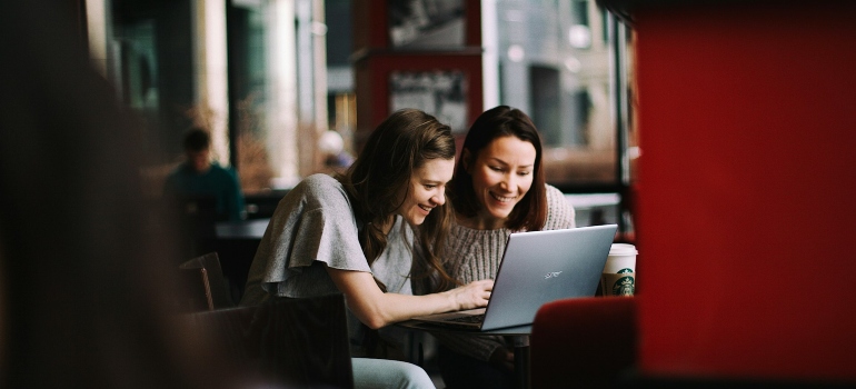 Picture of friends reading an expat guide to Canada on a laptop
