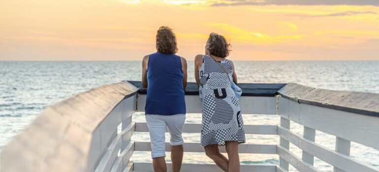 Two people standing on a balcony looking over the beach in Naples, FL