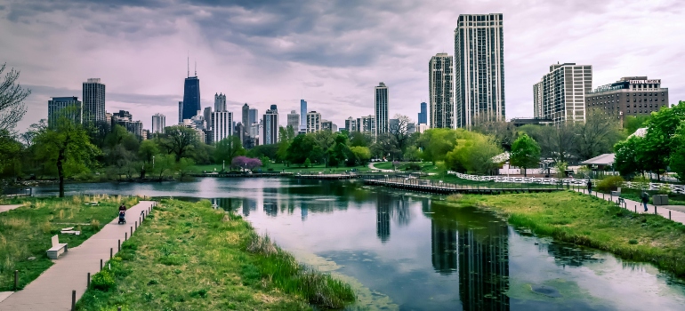 River Near City Buildings Under Cloudy Sky