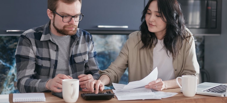 A couple is calculating utility bills after discussing what is making so many Canadians leave Canada.