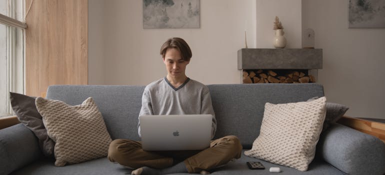 Man sitting on the couch and thinks about things to pack and things to leave in storage when leaving Canada
