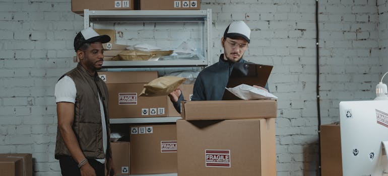 Two men standing in front of boxes