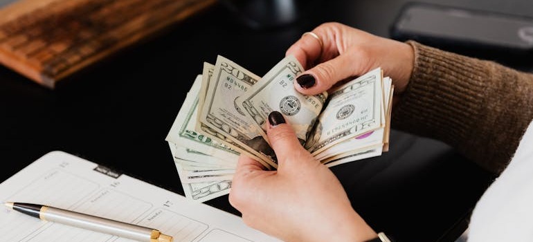 A person counting money, thinnig about mistakes to avoid when moving from Canada to USA