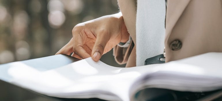 A person looking at documents in order to research & compare different moving companies in Canada