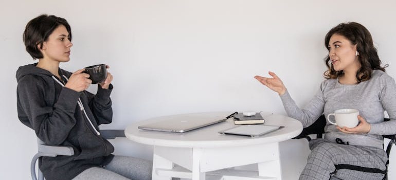 Two friends talking about how to research & compare different moving companies in Canada