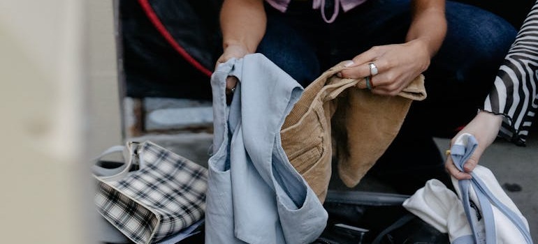 A person sorting out clothes before moving from Moncton to Scarborough
