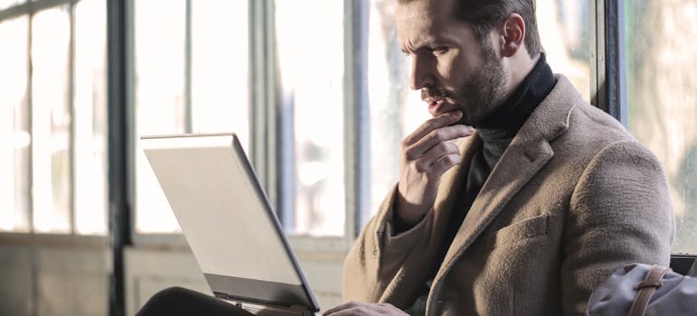 a man reading on laptop about movers in Whitby are the key to a hassle-free moving