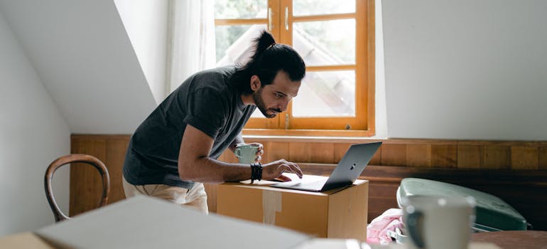 a man reading on a laptop about packing strategies to maximize space in your storage