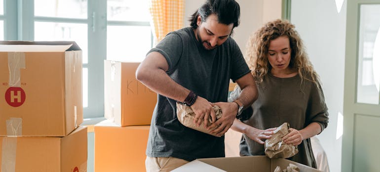 a man and a woman using packing strategies to maximize space in your storage