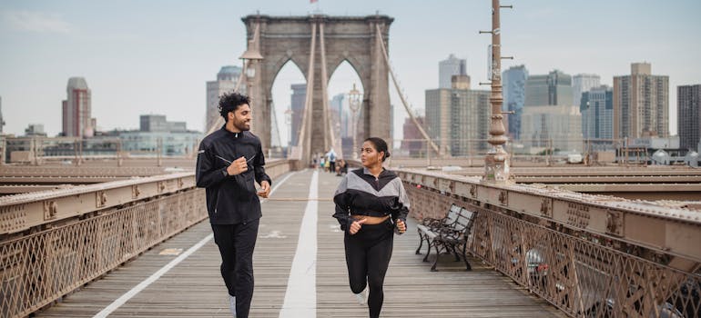 a man and a woman jogging over the bridge