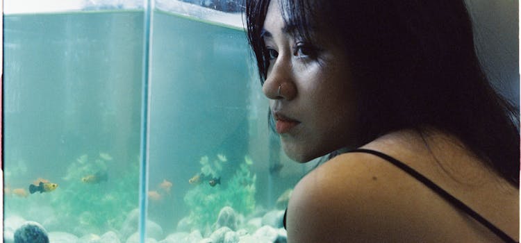 A woman looking at her fish tank