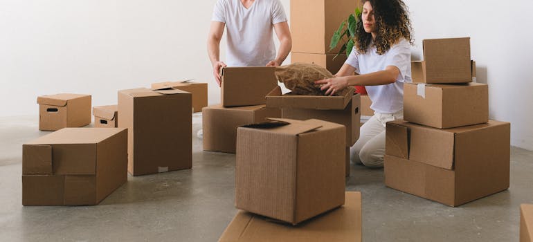 a man and a woman surrounded by boxes on the floor