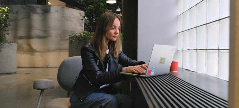 a woman reading on a laptop about the best cities for a fresh start in 2025
