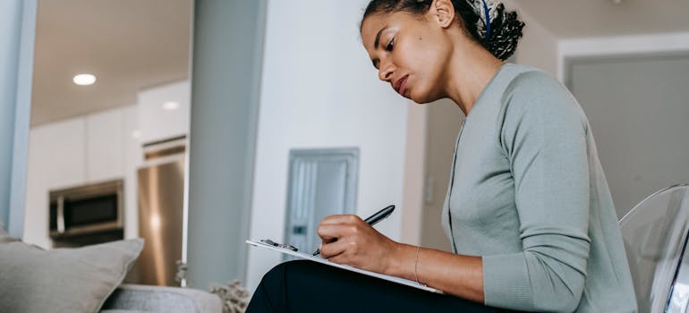 a woman sitting and writing on a piece of paper