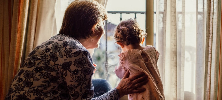 Child and adult looking through a window