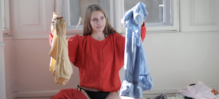 Person decluttering clothes in order to have an effortless moving process