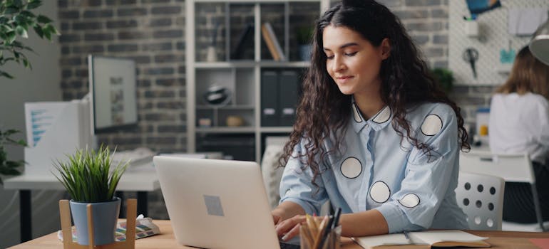 a woman sitting at the desk and writing on a laptop about are smart homes harder to move