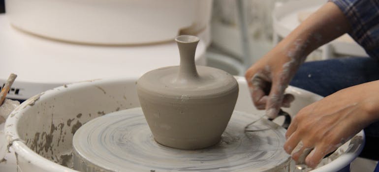 a person making a clay pot