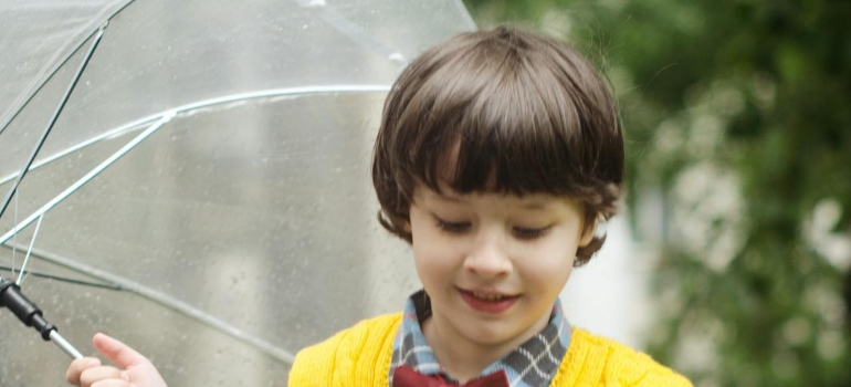 Kid holding an umbrella