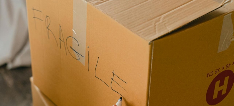 Person labeling a box before they pack and move musical instruments in Toronto
