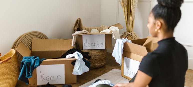 a woman trying to fulfil the ‘unpack in a day’ challenge in front of carboard boxes