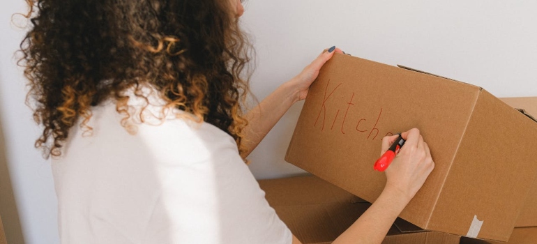 Person writing labels on a box