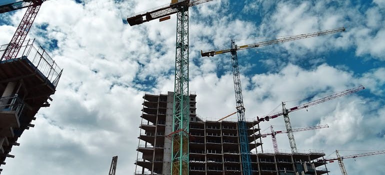 Green and yellow cranes on a construction site