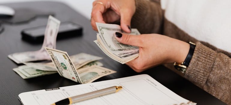 A person counting money after comparing local vs. long distance movers in Toronto