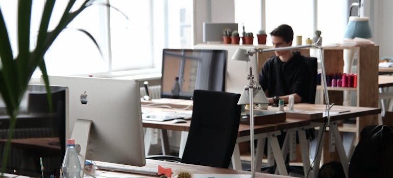 Man sitting in front of a computer and thinking about provinces to live in Canada for 2025