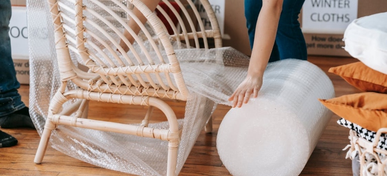 A person wrapping up a chair to prevent it from breaking
