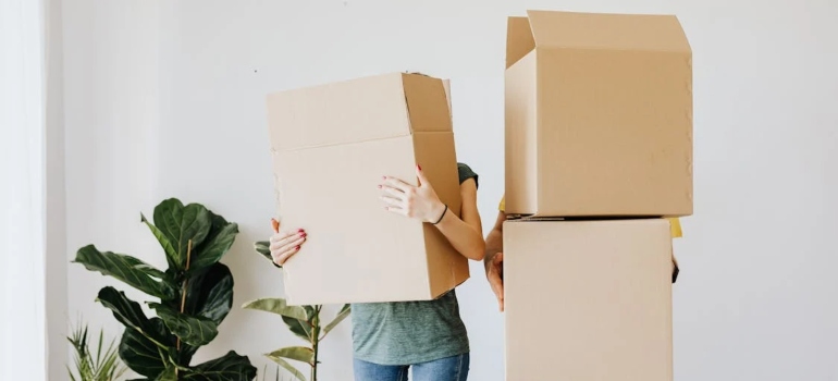 People carrying boxes that cover them