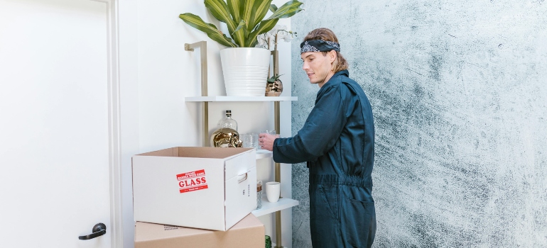 A mover packing delicate items into boxes—raising questions about what most moving companies won’t tell you.